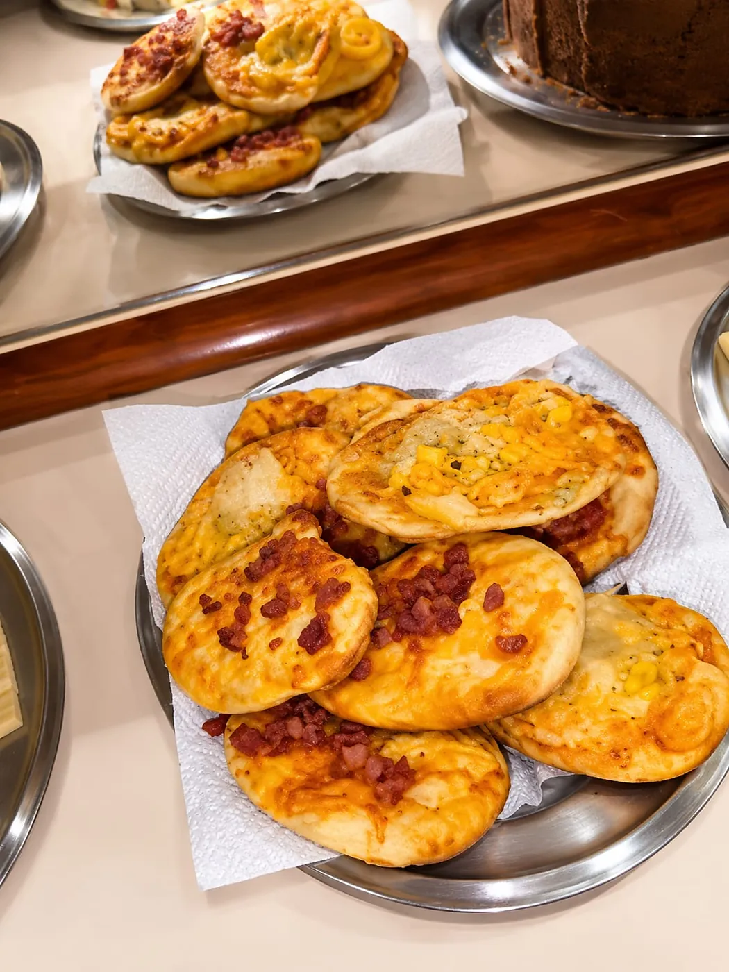 Pizzetas assadas de queijo, bacon e milho no café da manhã do Hotel Tubarão