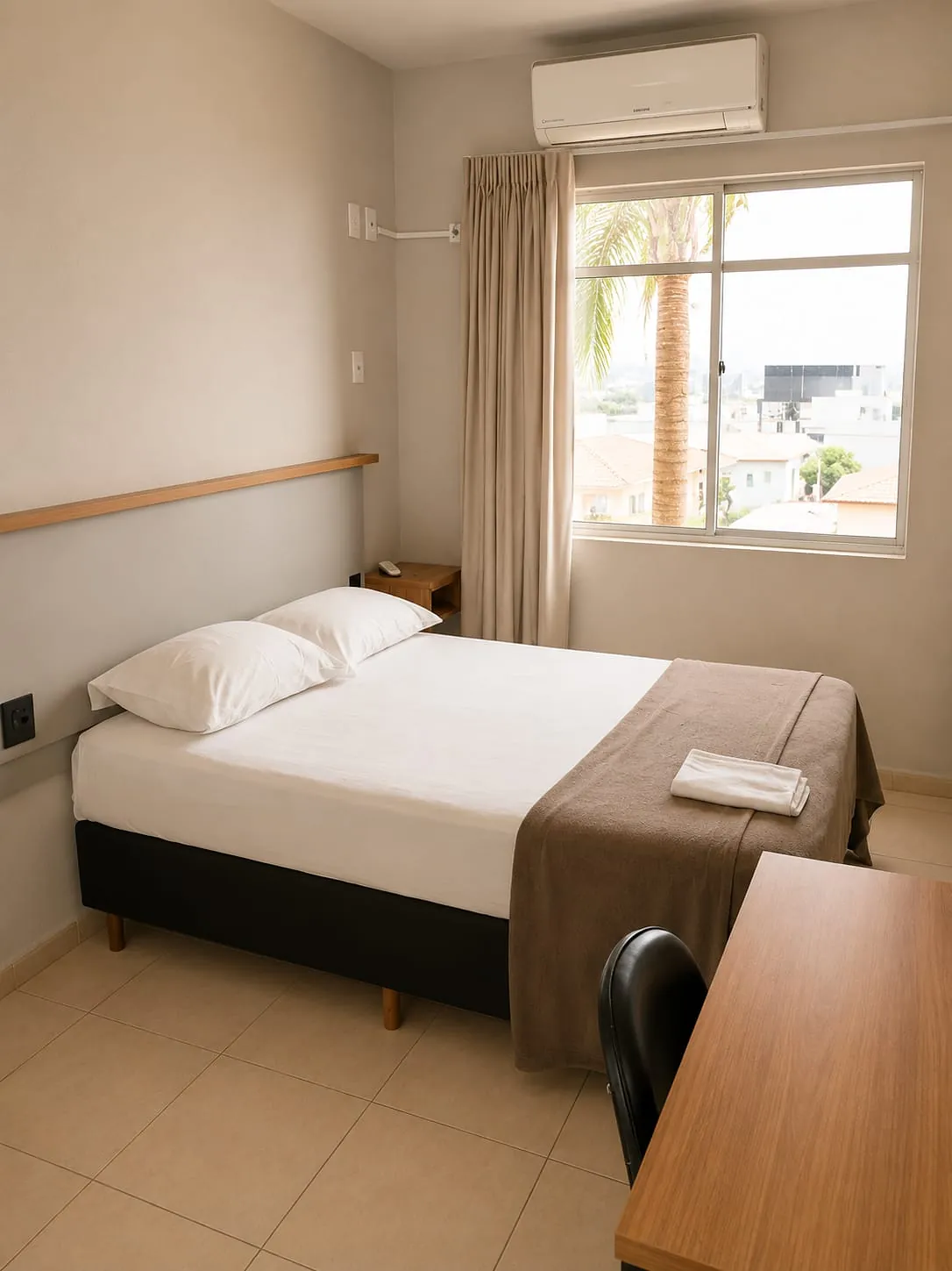 Quarto Premium Casal com janela ampla, cortinas e vista para as palmeiras, no Hotel Tubarão