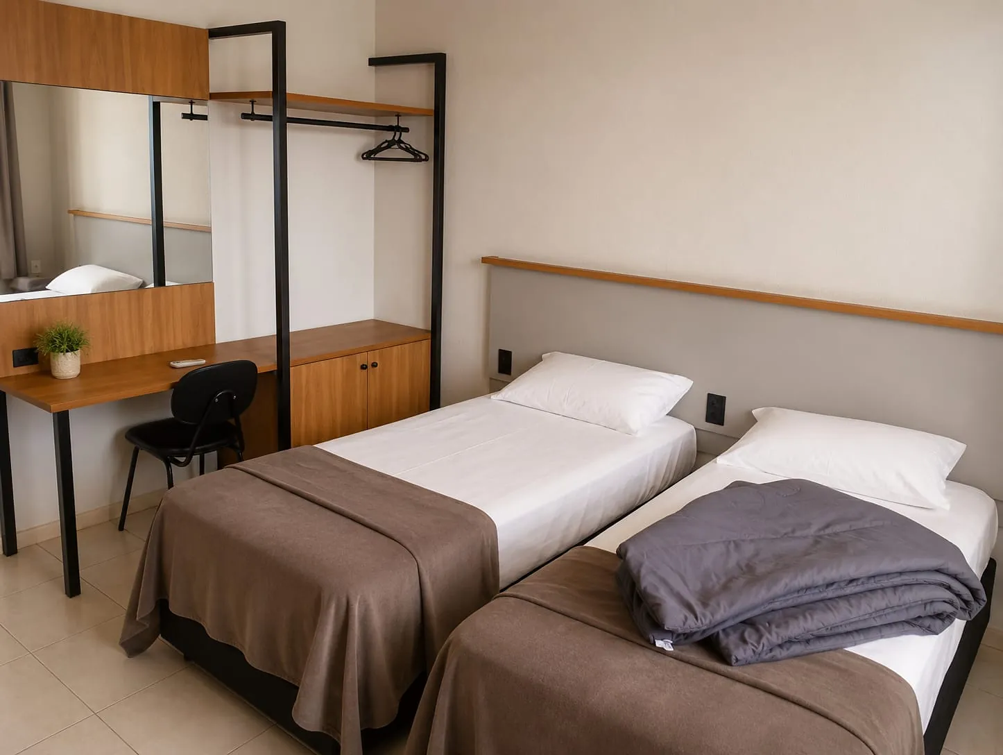 Quarto Premium Família do Hotel Tubarão: visão geral com escrivaninha com espelho, arara para roupas e camas arrumadas